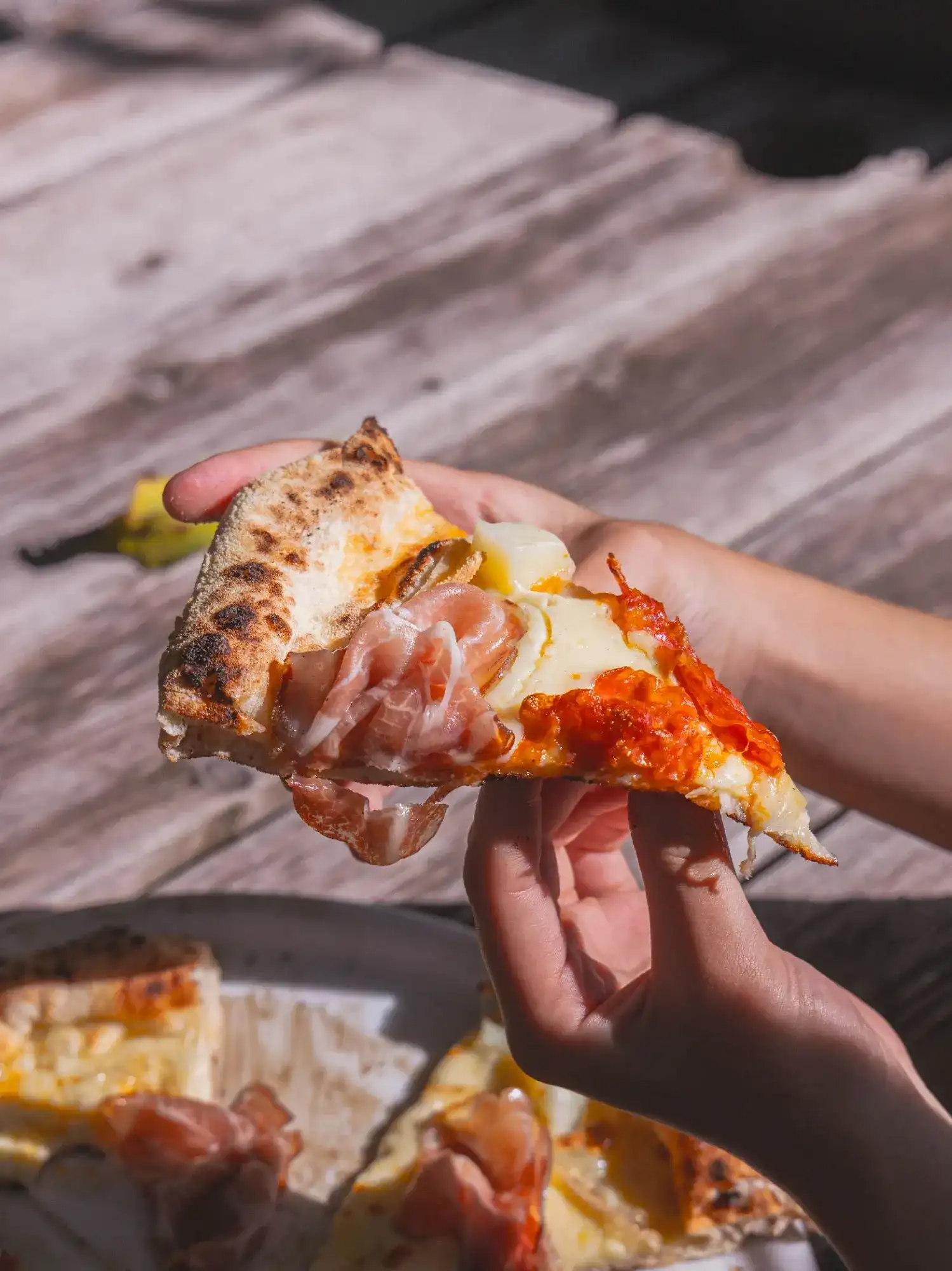 Une part de pizza napolitaine à la main
